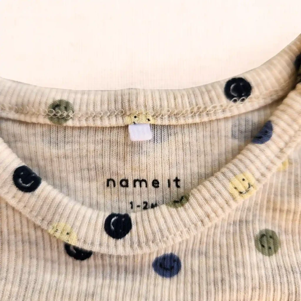 بادی آستین بلند کبریتی خریدطرح شکلک های خندان رنگ کرم برند name it