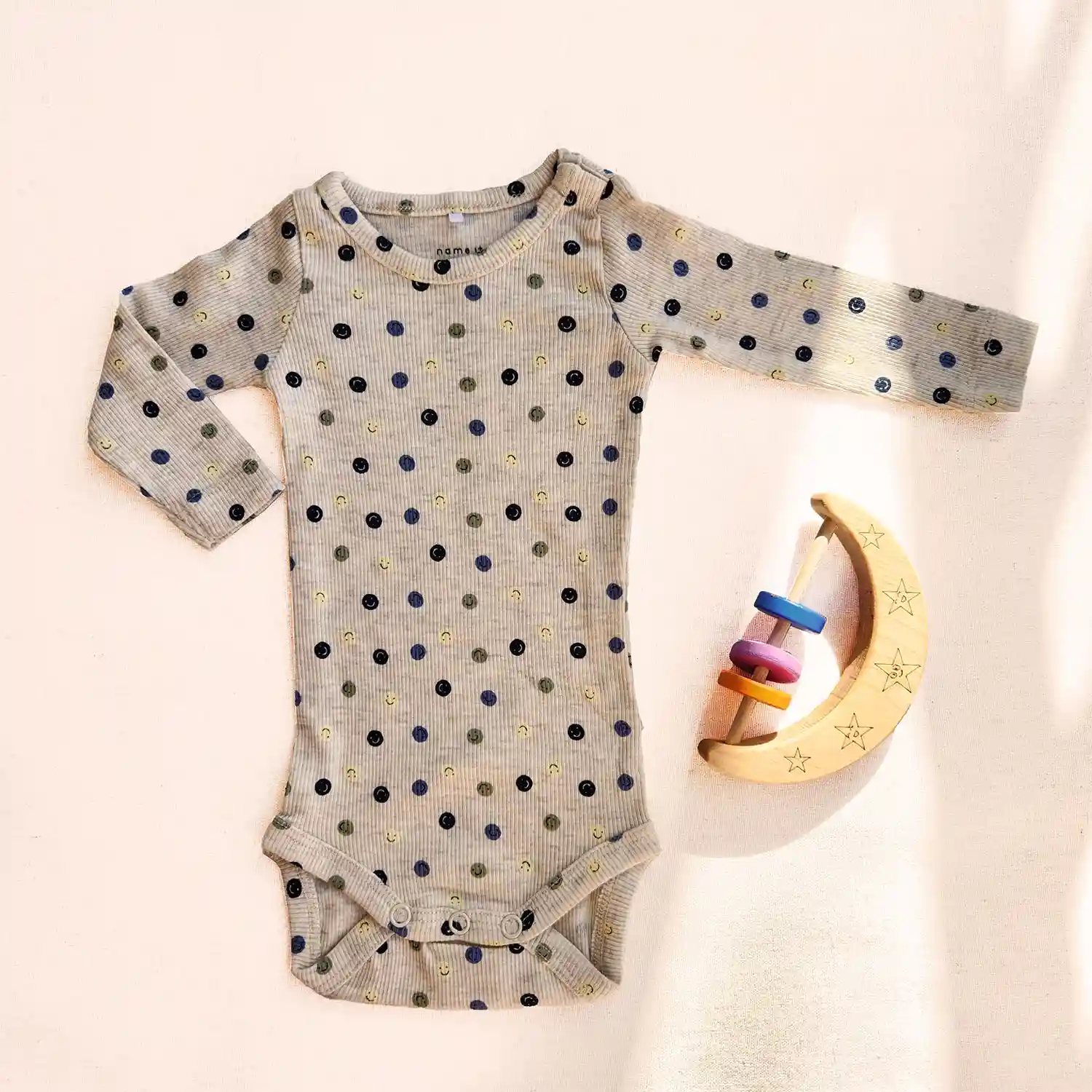 بادی آستین بلند کبریتی طرح شکلک های خندان رنگ کرم برند name it بادی آستین بلند کبریتی طرح شکلک های خندان رنگ کرم برند name it