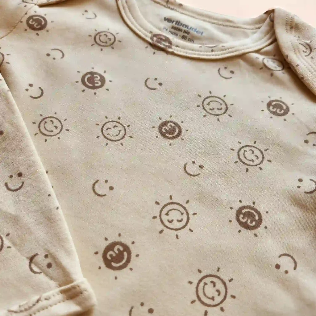 بادی آستین بلند طرح خورشید خندان رنگ کرم برند ورت بایودت