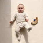 تن خور سرهمی نوزادی بافت وارداتی یقه هفت جوراب دار ساده رنگ کرم برند Baby Baby