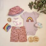 ست وارداتی بادی و شلوارک به همراه کلاه و جوراب طرح رنگین کمان رنگ یاسی